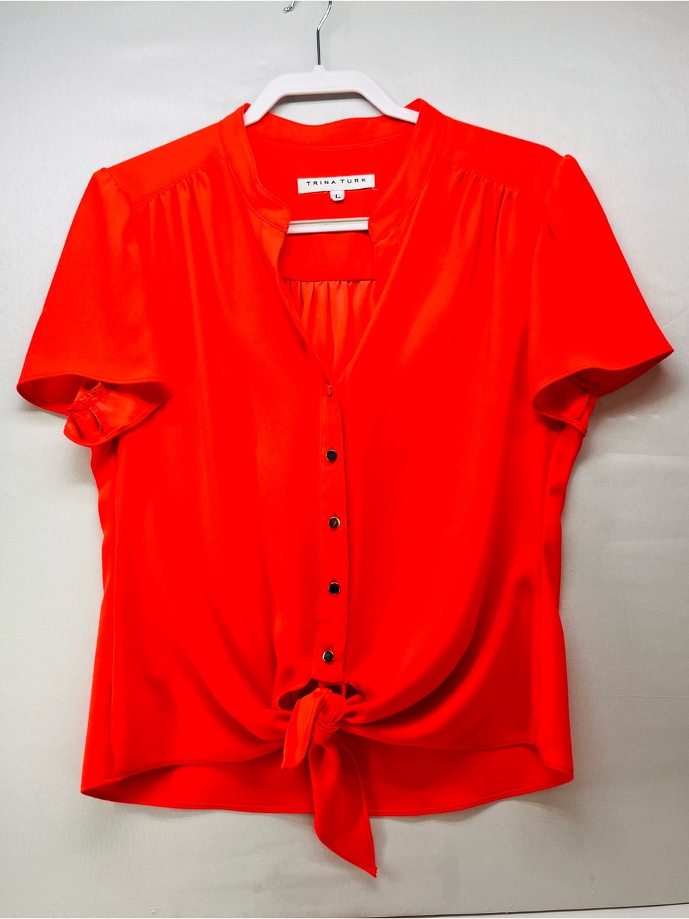 Trina Turk Gullah 2 red-orange blouse with a button-front and knot-tie hem